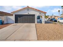 Single-story home with a dark gray garage door and rock landscaping at 2781 Sandyfalls Way, Las Vegas, NV 89142