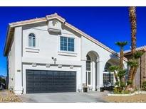 Two-story house with a black garage door and landscaping at 8896 Dove Cove Dr, Las Vegas, NV 89129