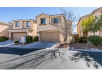 Two-story house with tan siding, attached garage, and landscaping at 9279 Cabin Cove Ave, Las Vegas, NV 89148