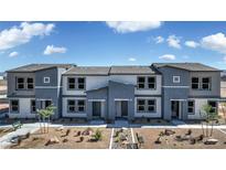 Modern two-story townhome with gray and beige exterior, landscaping, and walkway at 9315 Jade Mesa St # Lot 62, Las Vegas, NV 89139