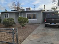 House exterior features a gray front, driveway, and small front yard with bushes at 1920 Walnut Ave, Las Vegas, NV 89101