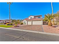 Two-story house with a tile roof, two-car garage, and landscaped yard at 5112 Palm View Dr, Las Vegas, NV 89130