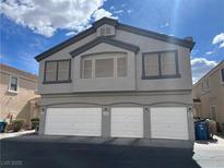 Three car garage exterior of home with gray paint and a window on the second story at 6449 Stone Dry Ave # 101, Henderson, NV 89011