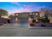 Two-story house with a three-car garage and landscaped front yard at 1137 Glistening Point Ave, Henderson, NV 89015