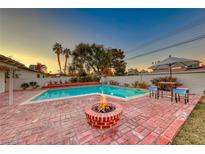 Inviting backyard with sparkling pool, fire pit, and brick patio at 2908 Bryant Ave, Las Vegas, NV 89102