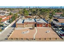 Aerial view of a large house with a spacious yard, and a city view in the background at 3070 Mann St, Las Vegas, NV 89146