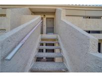 Inviting condo exterior featuring textured walls, a stairway, and the entrance to unit 118 at 3791 Desert Marina Dr # 118, Laughlin, NV 89029
