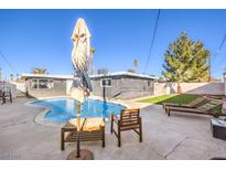 Inviting backyard oasis featuring a sparkling pool, lounge chairs, and patio furniture at 3809 San Angelo Ave, Las Vegas, NV 89102