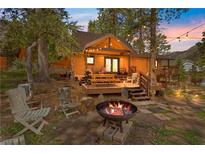 Cozy log cabin with firepit, deck, and seating area in the backyard at 4187 Matterhorn Way, Mount Charleston, NV 89124