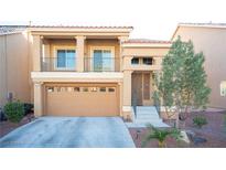 Two-story house with tan exterior, two-car garage, and balcony at 5391 Kennedy Hill Ave, Las Vegas, NV 89139