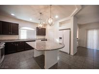 This open kitchen features granite countertops, an island, and stainless steel appliances at 5391 Kennedy Hill Ave, Las Vegas, NV 89139