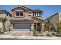 Two-story house with gray garage door, orange accents, and landscaped yard at 10640 Skye Scout Ave, Las Vegas, NV 89166