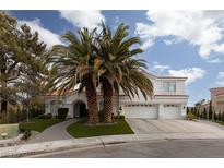 Two-story house with white exterior, palm trees, and a three-car garage at 2000 Catalina Marie Ave, Henderson, NV 89074