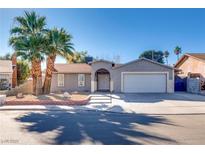 Single-story house with a two-car garage and landscaped front yard at 6725 Carrera Dr, Las Vegas, NV 89103