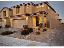 Two-story house with attached garage, landscaping, and a brick driveway at 8976 Sweet Chestnut Ln, Las Vegas, NV 89178