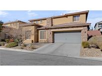 Two-story house with stone accents and a gray garage door at 10350 Blue Ginger Dr, Las Vegas, NV 89135