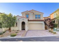 Two-story house with tan siding, tile roof, and landscaped yard at 12237 Olivetta Ct, Las Vegas, NV 89138