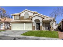 Two-story house with a three-car garage and landscaped lawn at 10016 Diving Duck Ave, Las Vegas, NV 89117