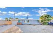 Ranch style home with gray exterior, white garage door, and landscaping at 1205 Sattes St, Las Vegas, NV 89101