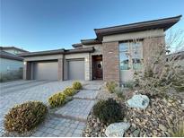 Modern two-story home with a three-car garage and landscaped front yard at 12422 Tudor Arch Dr, Las Vegas, NV 89138