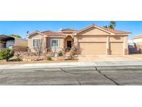 Tan two-story house with a three-car garage and desert landscaping at 1426 Radig Ct, Boulder City, NV 89005