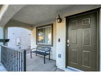 Inviting front porch with bench and dark brown door at 6461 Karlsen Ct, Las Vegas, NV 89122