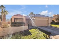 Single-story house with a two-car garage and landscaped yard at 309 Wild Plum Ln, Las Vegas, NV 89107