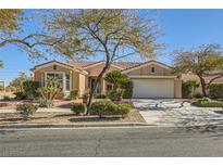 Single-story home with attached garage, landscaping, and a large tree in the front yard at 4750 Fiore Bella Blvd, Las Vegas, NV 89135