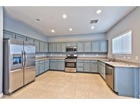 Well-lit kitchen featuring stainless steel appliances and gray cabinets at 5555 Sun Temple Ave, Las Vegas, NV 89139