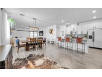 Open concept dining area with wood table and modern lighting at 6318 Amber Sunrise St, North Las Vegas, NV 89031