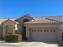 Tan house with tile roof, two-car garage, and landscaping at 22 Arborfield Ct, Henderson, NV 89012