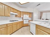 Bright kitchen features wooden cabinets, white countertops, and modern appliances at 2617 Huber Heights Dr, Las Vegas, NV 89128