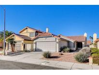 Two-story house with Spanish tile roof, attached two-car garage, and desert landscaping at 321 Carrington St, Henderson, NV 89074