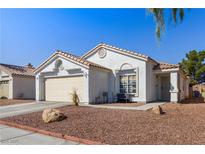 Single-story house with beige exterior, two-car garage, and landscaped front yard at 3327 Outlook Point St, North Las Vegas, NV 89032