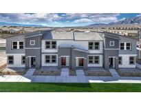 Modern three-unit townhome complex with gray siding, and landscaping at , North Las Vegas, NV 89084