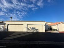 Two-car garage with beige doors and asphalt driveway at 2148 Pebble Creek Ln, Laughlin, NV 89029