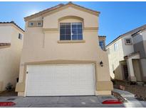 Two-story beige house with white garage door and landscaping at 2503 Lady Elizabeth Ct, North Las Vegas, NV 89031