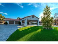 Single-story home with stone accents, landscaped yard, and two-car garage at 5353 Dorrell Ln, Las Vegas, NV 89131