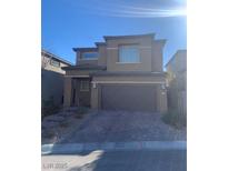 Two-story house with tan siding, brown garage door, and stone accents at 12381 Foxtail Run Ave, Las Vegas, NV 89138