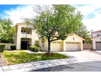 Two-story house with attached two-car garage, landscaping, and a tree in the front yard at 1813 Francisco Peak Pl, Las Vegas, NV 89128