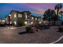 Attractive multi-unit building with landscaping and outdoor lighting at dusk at 4921 Black Bear Rd # 104, Las Vegas, NV 89149