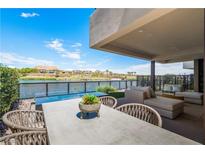 Covered patio with lake view, seating area, and dining table at 20 Lakefront Dr, Henderson, NV 89011