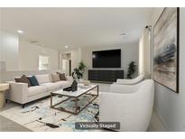 Bright, staged living room featuring stylish furniture, a large TV, and elegant decor at 7659 Dewy Falls Ave, Las Vegas, NV 89179