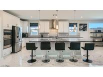 Spacious kitchen with stainless steel appliances, a large island, and modern white cabinetry at 6834 Compass St, North Las Vegas, NV 89084
