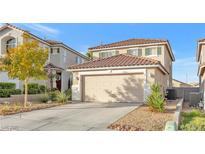 Two-story house with beige exterior, two-car garage, and landscaping at 1129 Majestic Canyon St, Henderson, NV 89052