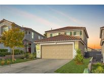 Two-story house with tan siding, attached garage, and landscaped yard at 1129 Majestic Canyon St, Henderson, NV 89052