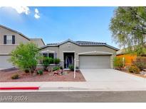 Tan one-story house with a two-car garage and landscaped yard at 1153 Pine Cove Ct, Henderson, NV 89011