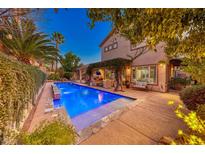 Stunning pool and spa with lush landscaping at night at 2412 Templi Scotia St, Henderson, NV 89044