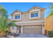 Two-story house with a beige exterior, two-car garage, and palm trees at 5993 Lambert Bridge Ave, Las Vegas, NV 89139