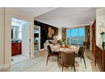 Bright dining area with a wooden table and four chairs, offering city views at 145 E Harmon Ave # 2120, Las Vegas, NV 89109